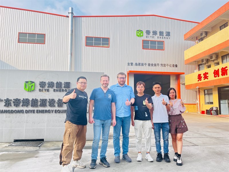 Six visitors giving a thumbs-up beside the Diye Energy sign wall