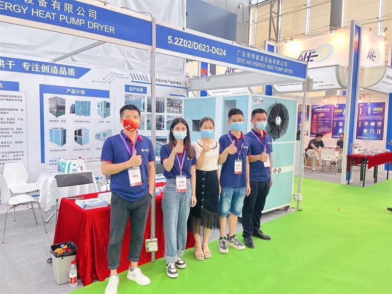 Five team members giving a thumbs-up in front of the booth at AHE 2022