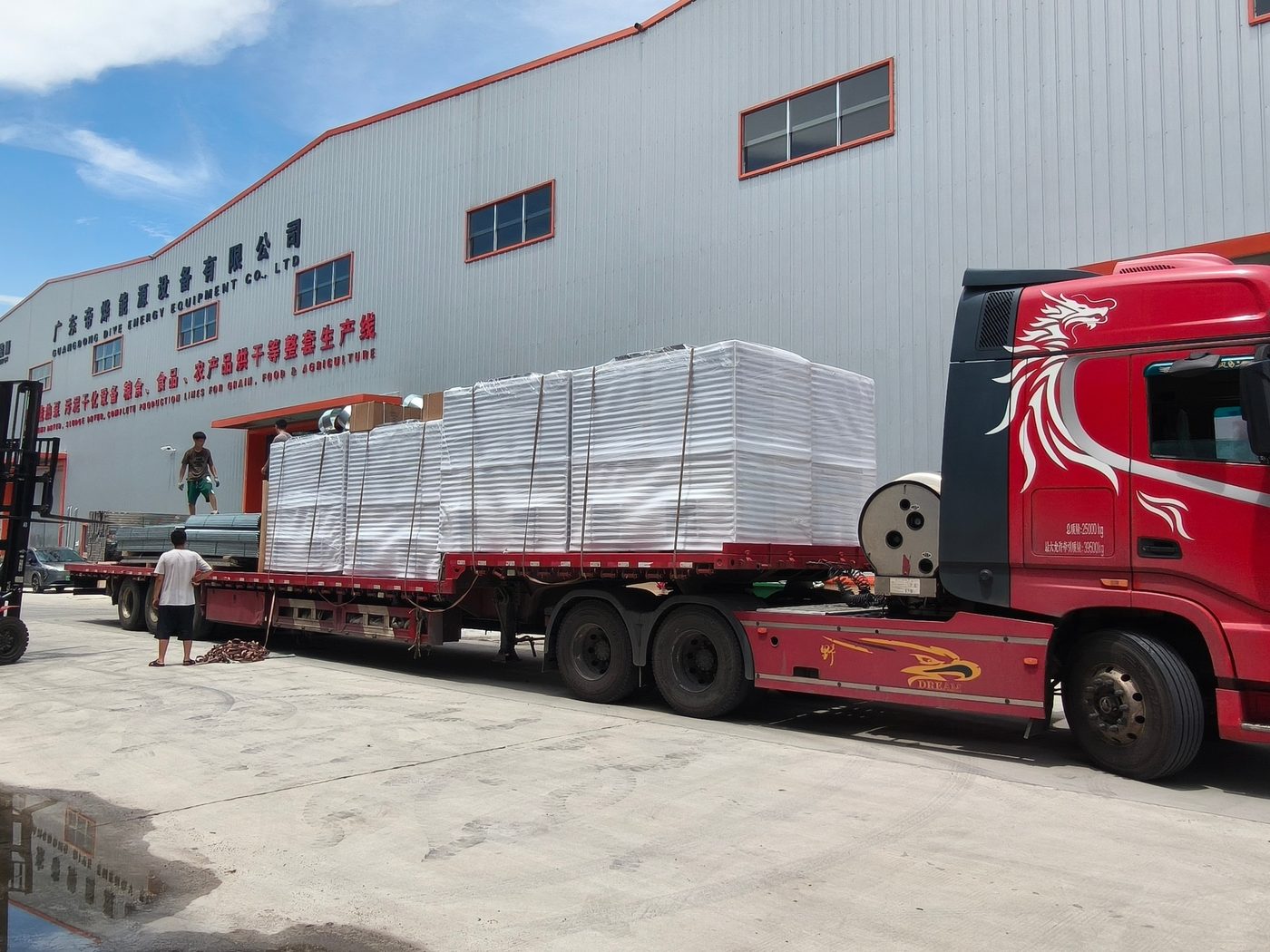 Loaded red flatbed in the factory yard with units and steel bundles at the dock door