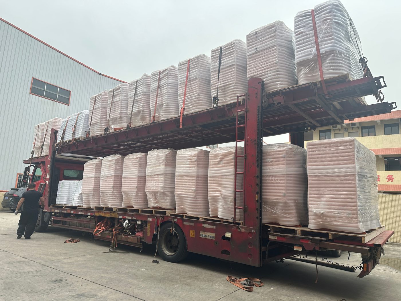Double-deck carrier fully loaded with shrink-wrapped units before departure